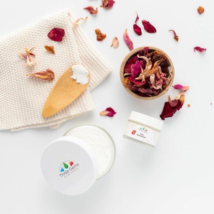 Three Gems organic shea body butter surrounded by rose petals