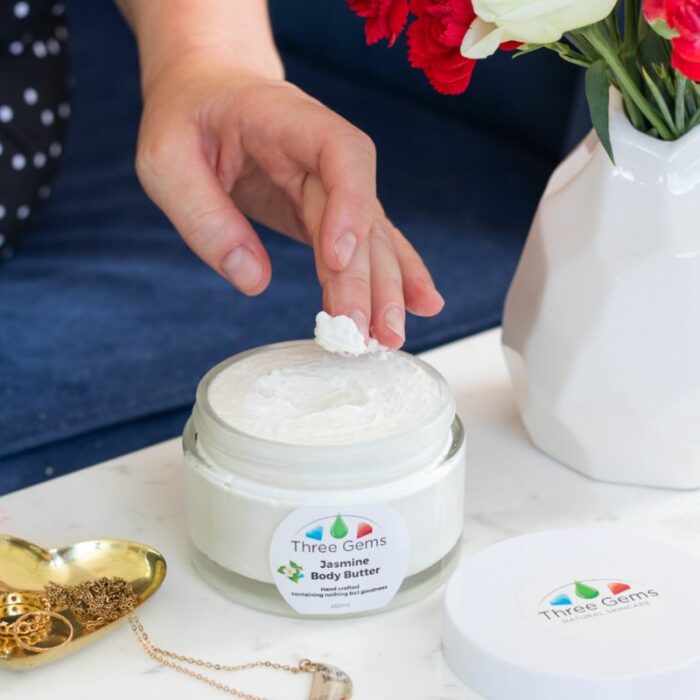 A lady using the Three Gems Organic Body Butter