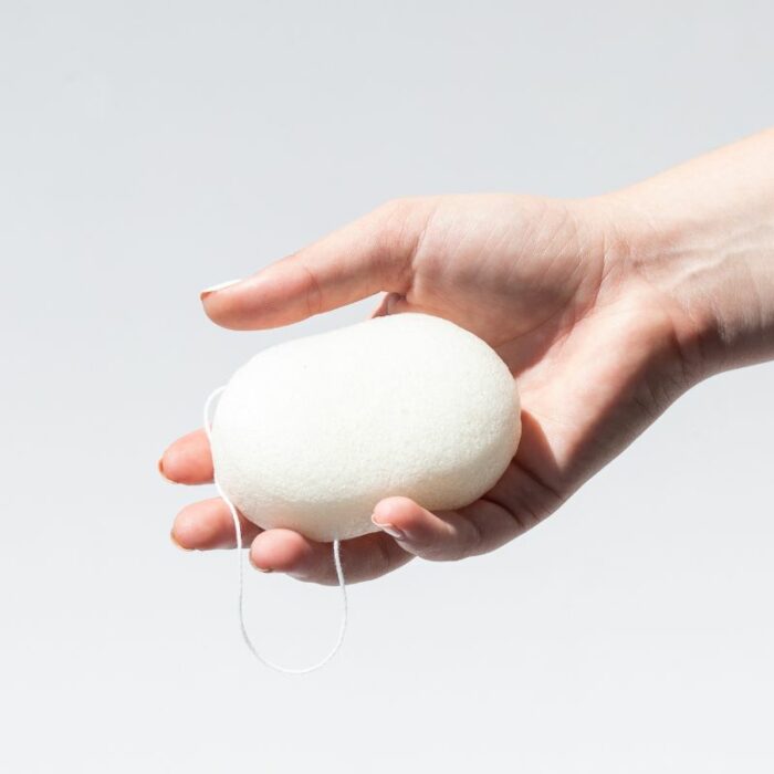 A natural white konjac sponge being held